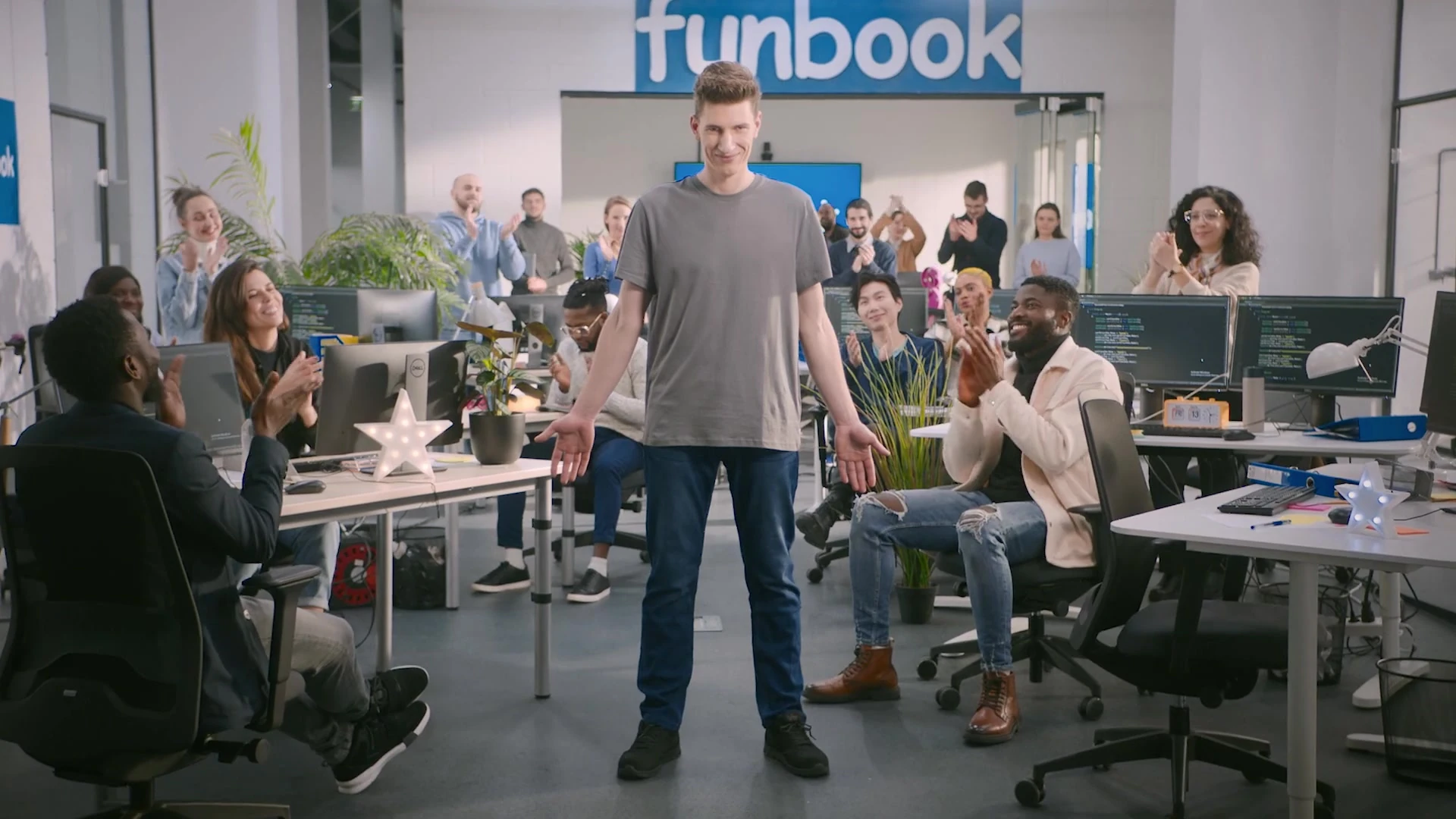 Funbook vadovas biure, apsuptas komandos.